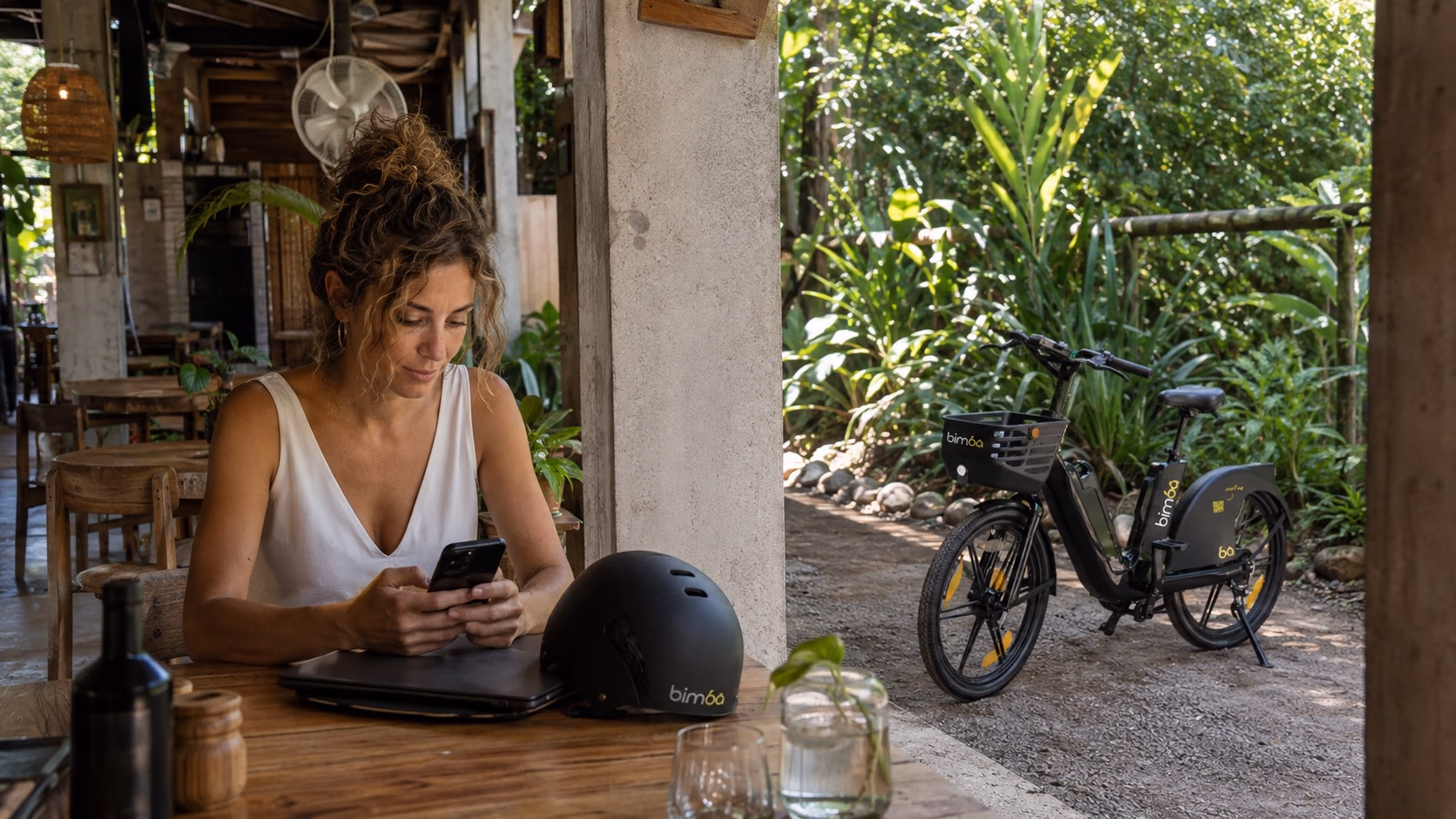Remote worker beside an exact-model Bimba e-bike at a Santa Teresa coworking café