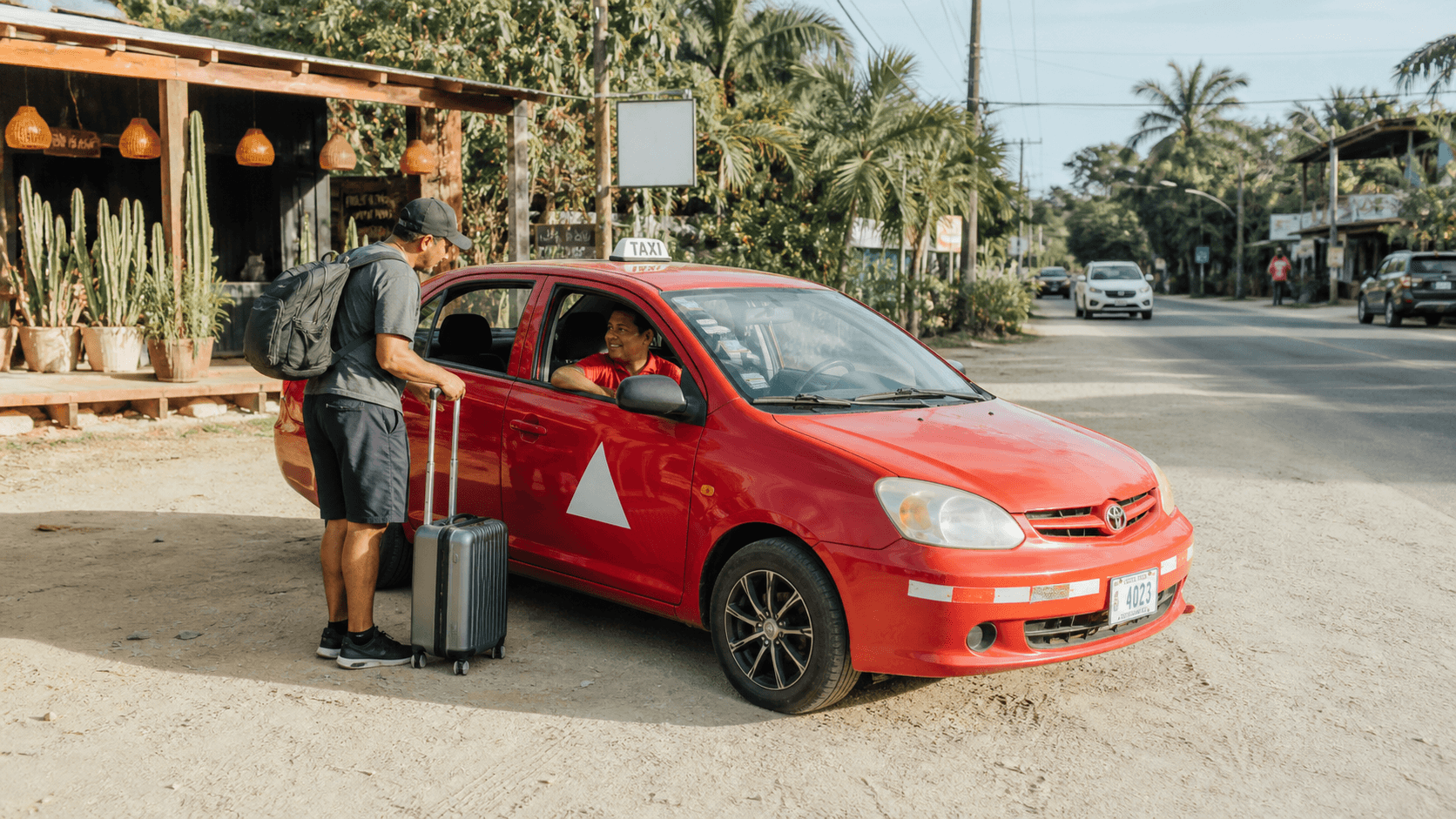 Traveler speaking with a licensed red taxi driver in Santa Teresa, Costa Rica