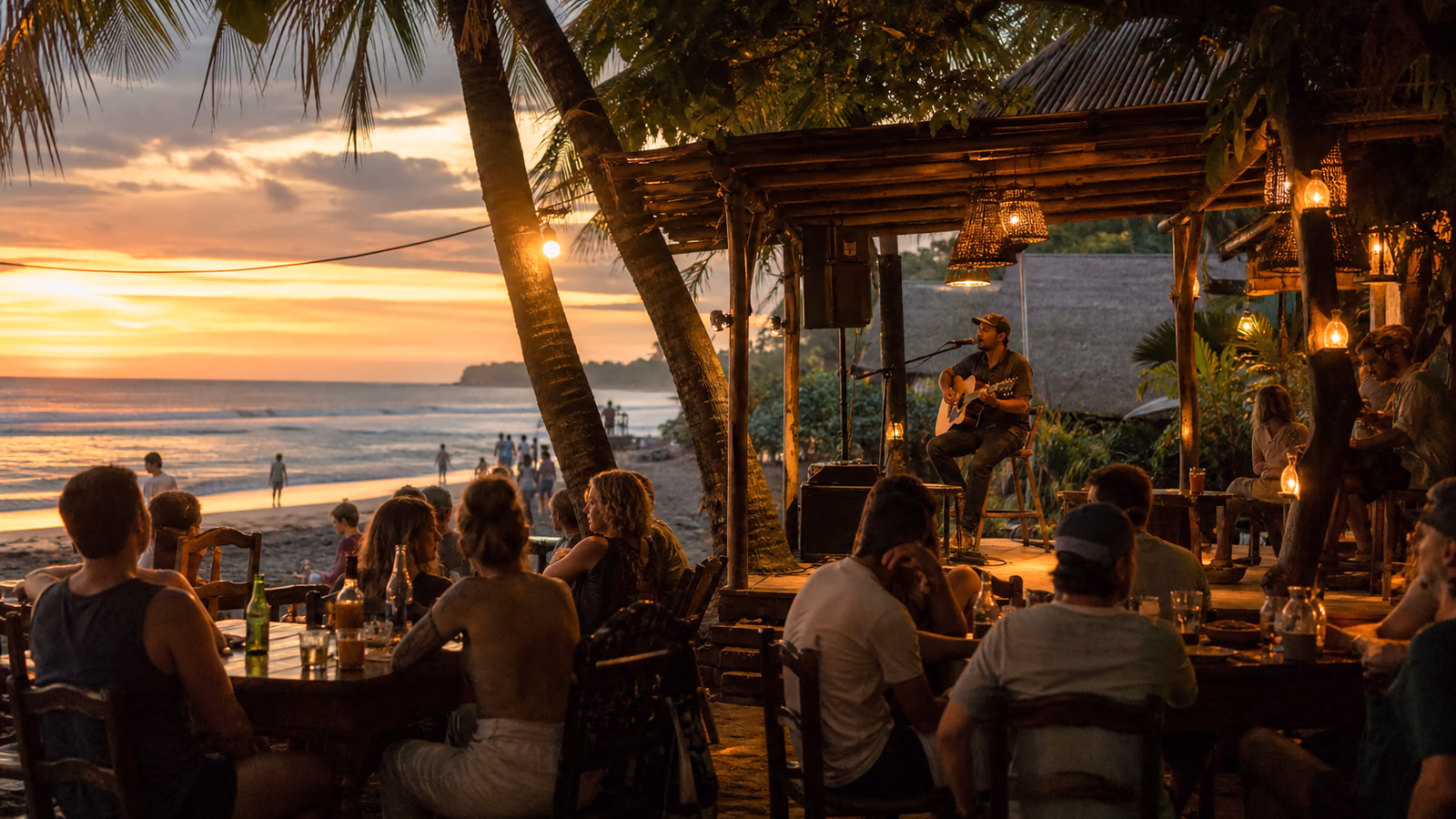 Acoustic musician performing for diners at a Santa Teresa beachfront restaurant at sunset