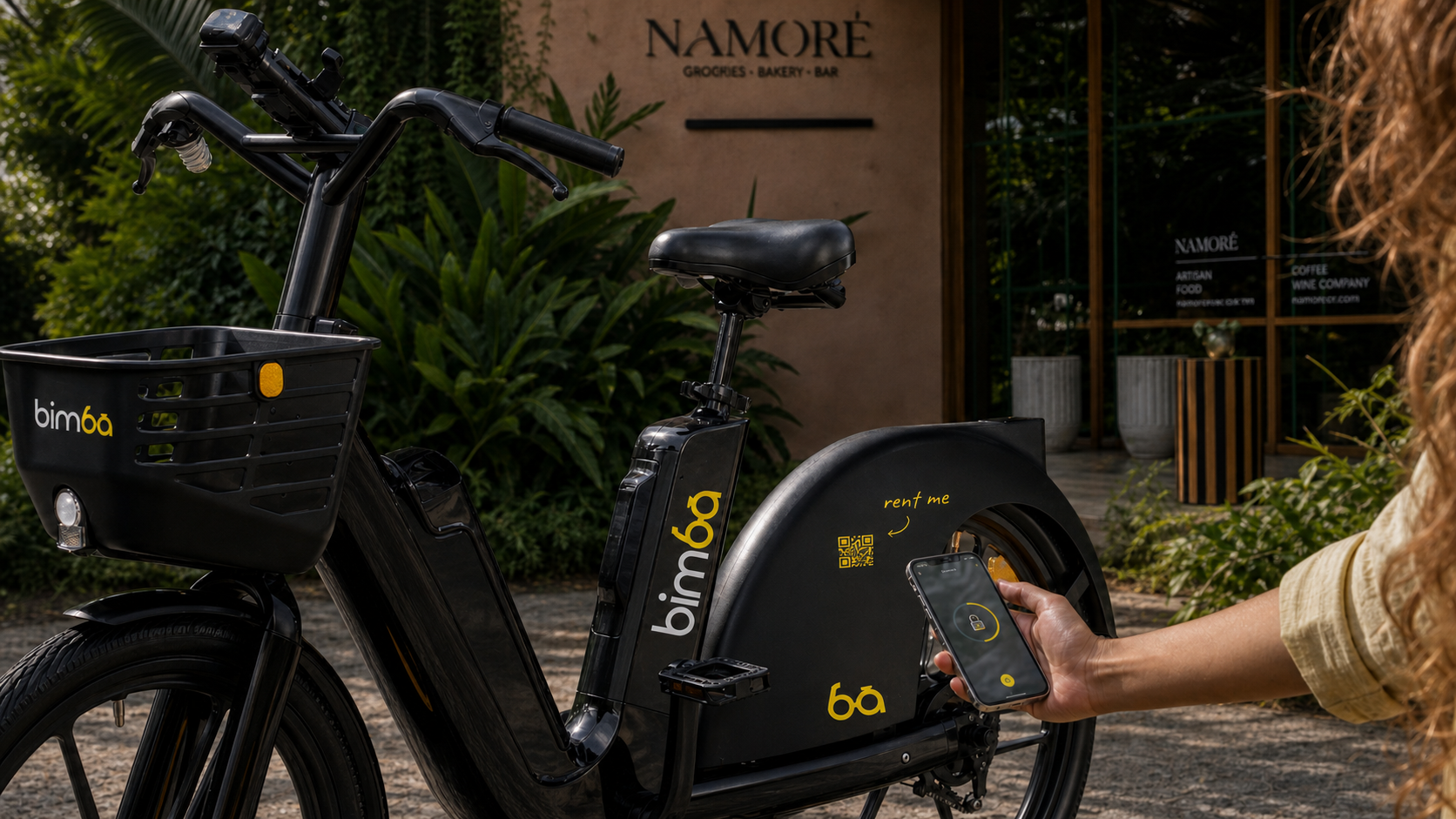 Persona escaneando el código QR de una bicicleta eléctrica Bimba frente a Namoré en Santa Teresa