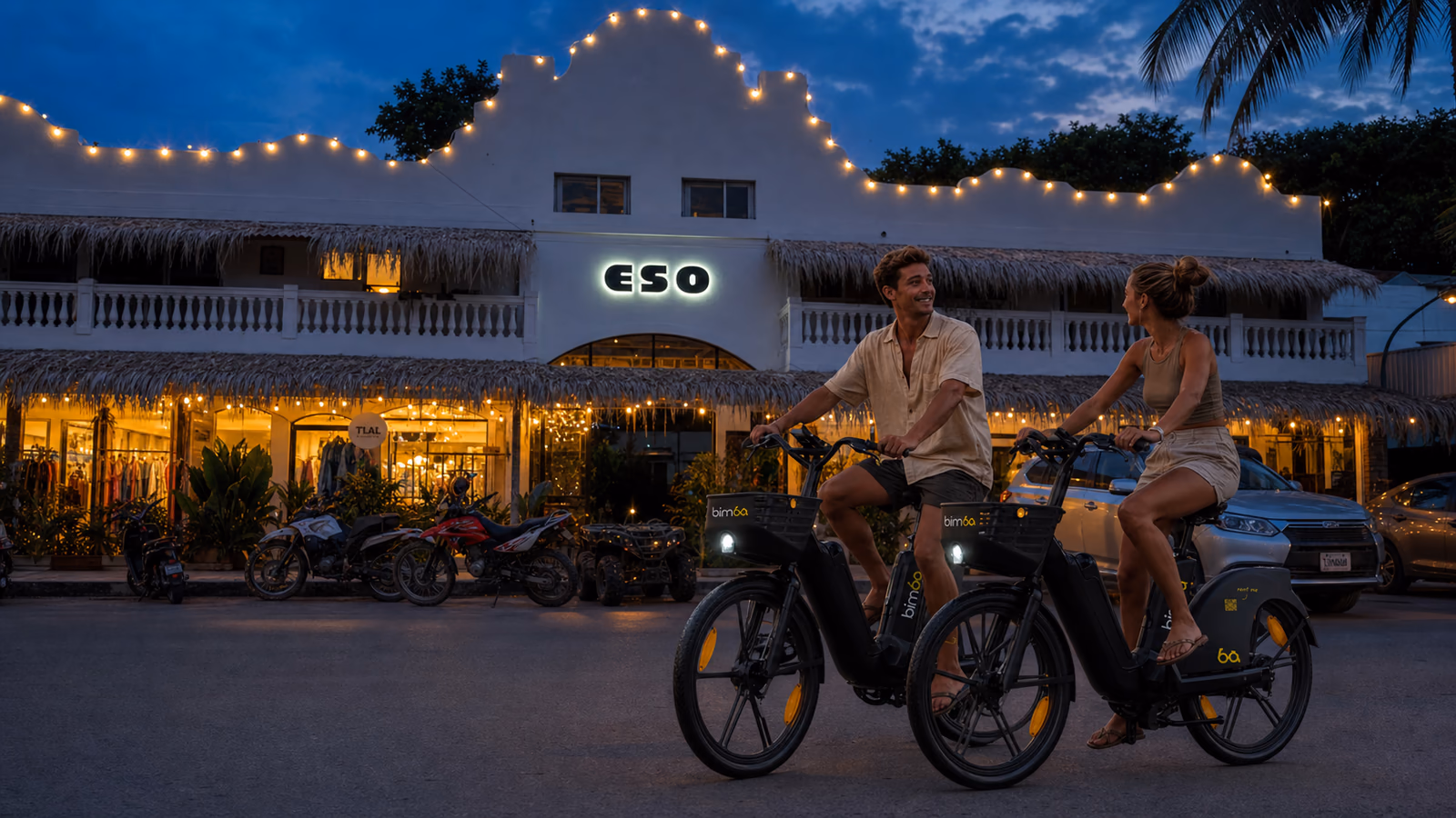 Two riders on Bimba electric bikes in Santa Teresa after sunset