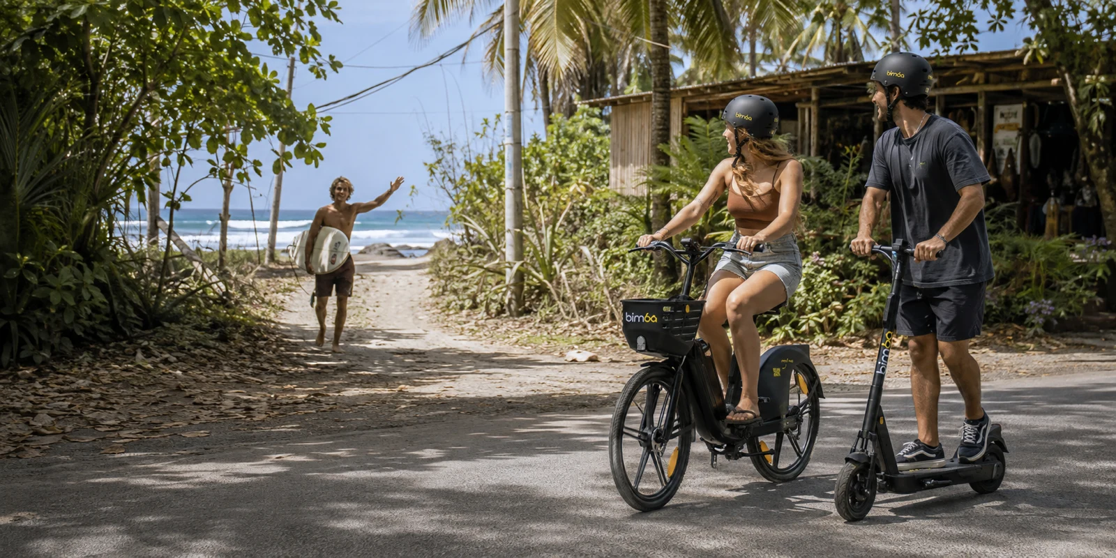 Amigos viajando en bicicletas y scooters eléctricos Bimba hacia la playa en Santa Teresa, Costa Rica