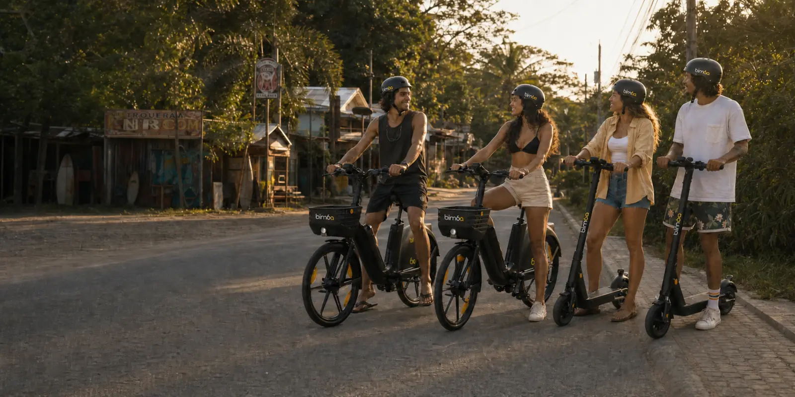 Personas viajando en bicicletas y scooters eléctricos Bimba por la calle principal de Santa Teresa, Costa Rica