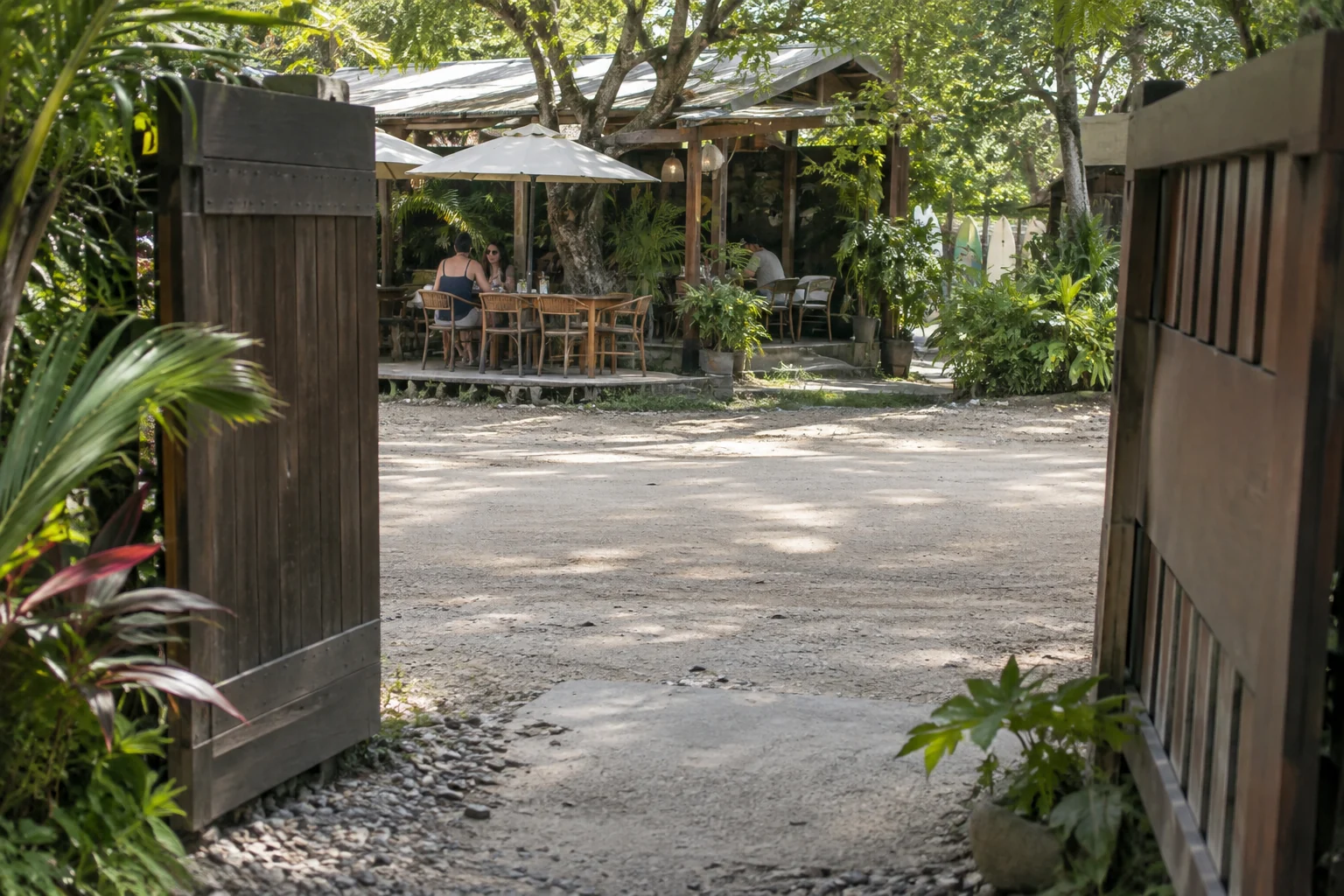 Entrada de una casa de huéspedes frente a una terraza de café al otro lado de una calle